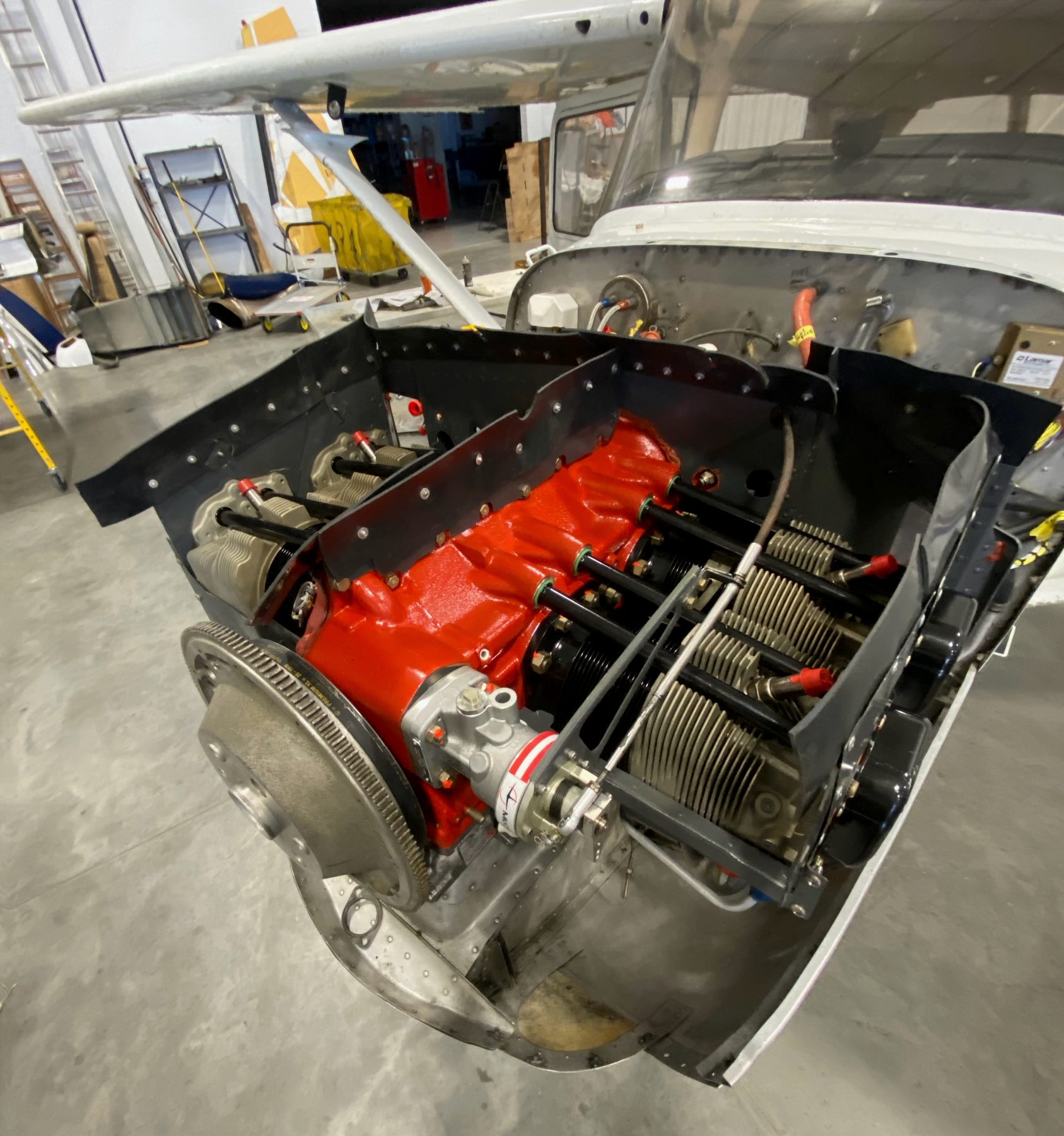 Single-engine Cessna with cowling off and freshly painted orange engine case